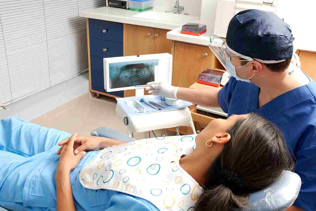 Dentist reviewing a digital dental X-ray with a patient in a modern treatment room, highlighting Loans for Dentists, Dental Loan Application options, Dental Website Financing, Dental Funding Providers, and Dental Software Financing solutions for practice growth and technology upgrades.