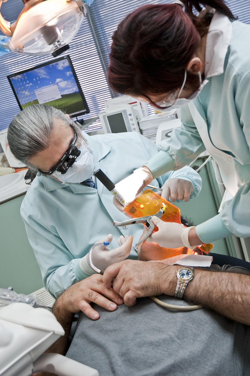 Dentist and dental assistant performing a procedure in a modern treatment room, representing CBCT Financing, New Dental Office Financing, Dental Practice Purchase Loans, Dental Office Expansion Loans, and Dental Office Renovation Financing for growing dental practices.