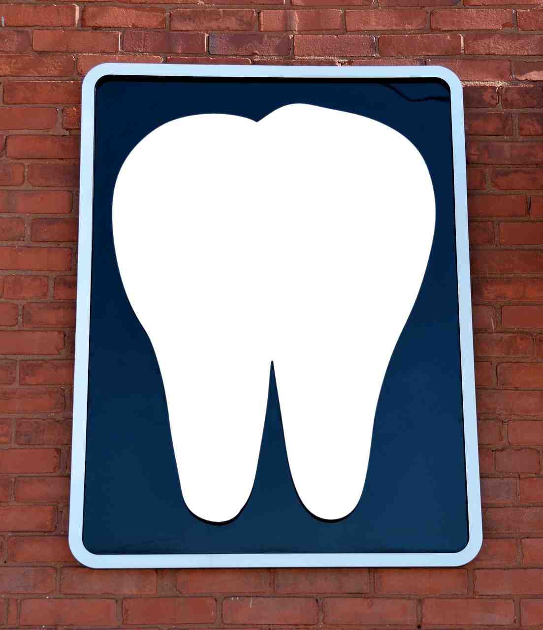 Dental clinic exterior sign featuring a tooth symbol mounted on a building, representing modern dental practice growth through Dental AI Technology Financing, Dental Staffing Financing, Dental Cloud Software Financing, Dental Operatory Financing, and Orthodontic Equipment Financing.
