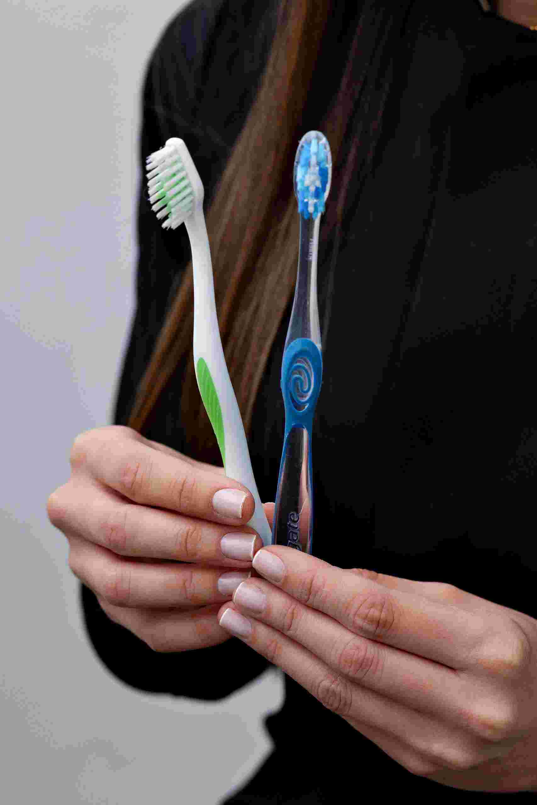Person holding two toothbrushes during a dental hygiene consultation, representing Orthodontic loans, funding a new dental office, orthodontic technology financing, oral surgeon startup loans, and dental revenue financing for modern dental and orthodontic practices.