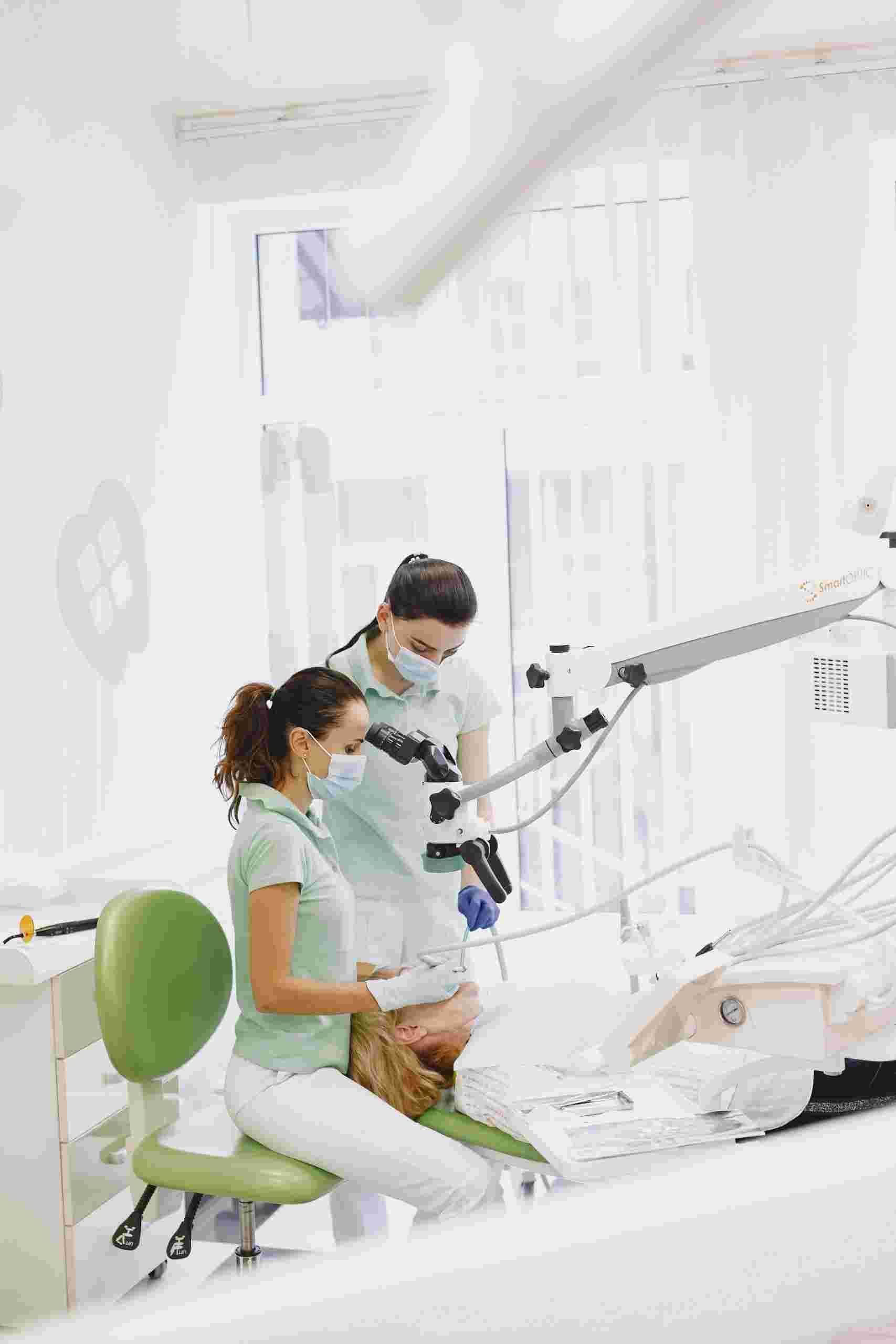 Modern dental practice under construction and operation with dental professionals treating a patient in a bright clinical operatory, representing dental office construction financing, dental receivables financing, dental cash flow financing, patient acquisition financing, and practice software funding for growing dental practices.