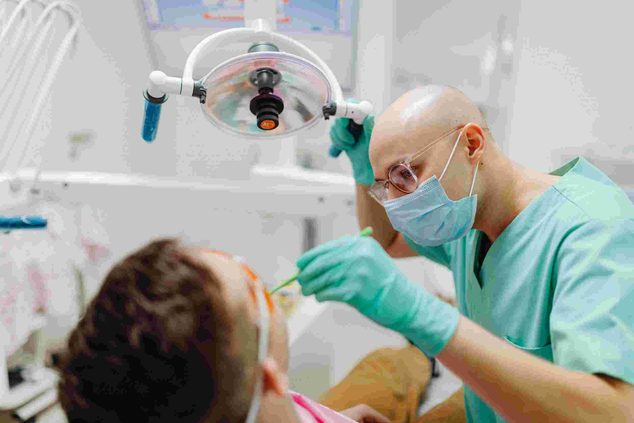 Dentist performing a patient examination in a modern treatment room, representing the educational investment behind Dental School Loans and the professional growth opportunities supported by Dental Loans for practice ownership, equipment purchases, and clinic expansion.