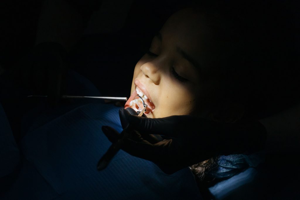Patient receiving a dental examination with a mouth mirror and dental instrument, representing Dental X-ray financing, dental startup financing, dental practice startup loans, superb dental clinic startup capital, and startup funding for dentists for new dental practices.